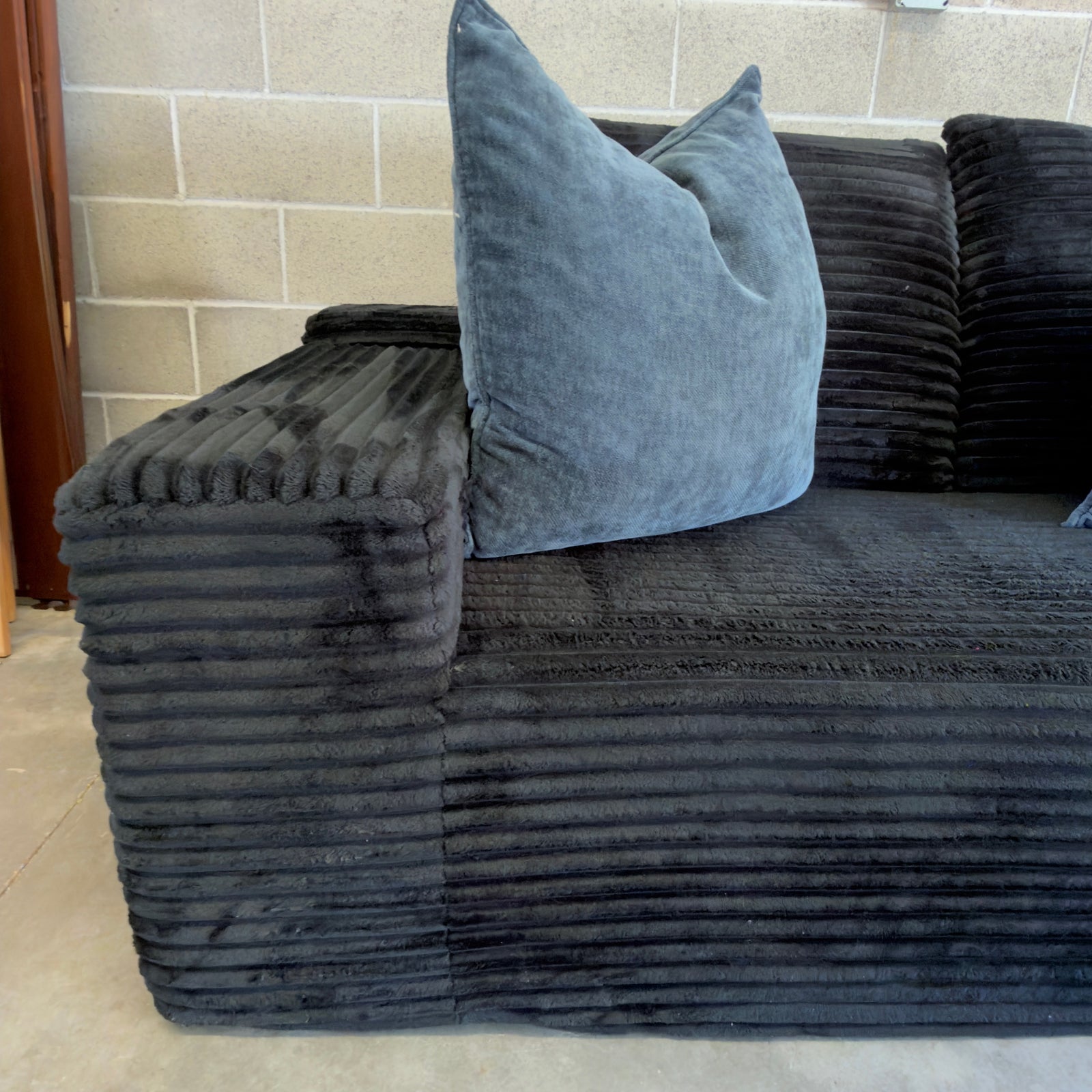 Black ribbed corduroy sectional - upholstery and padded arm close-up