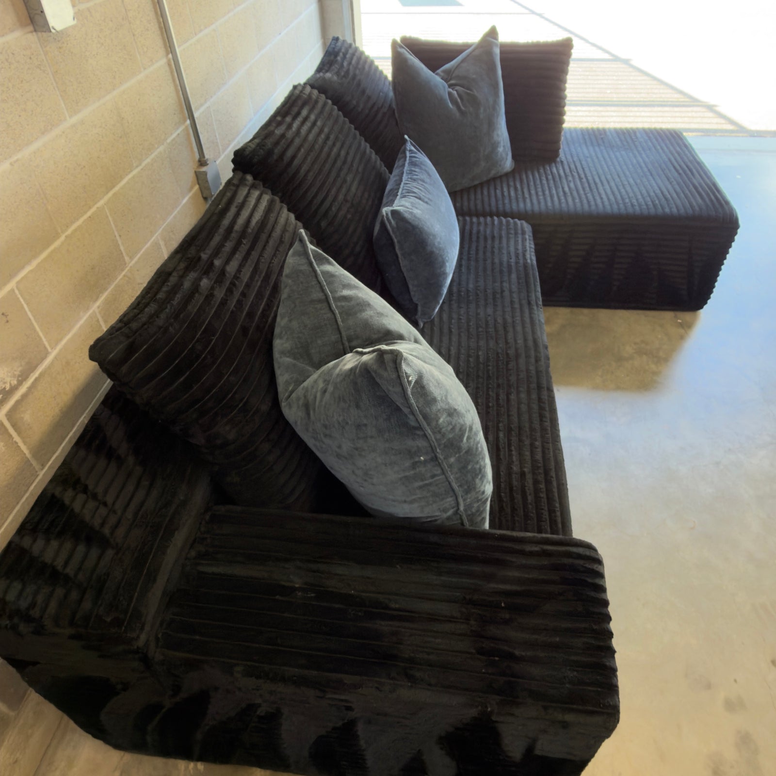 Black corduroy sectional - high-angle seat and back cushion view