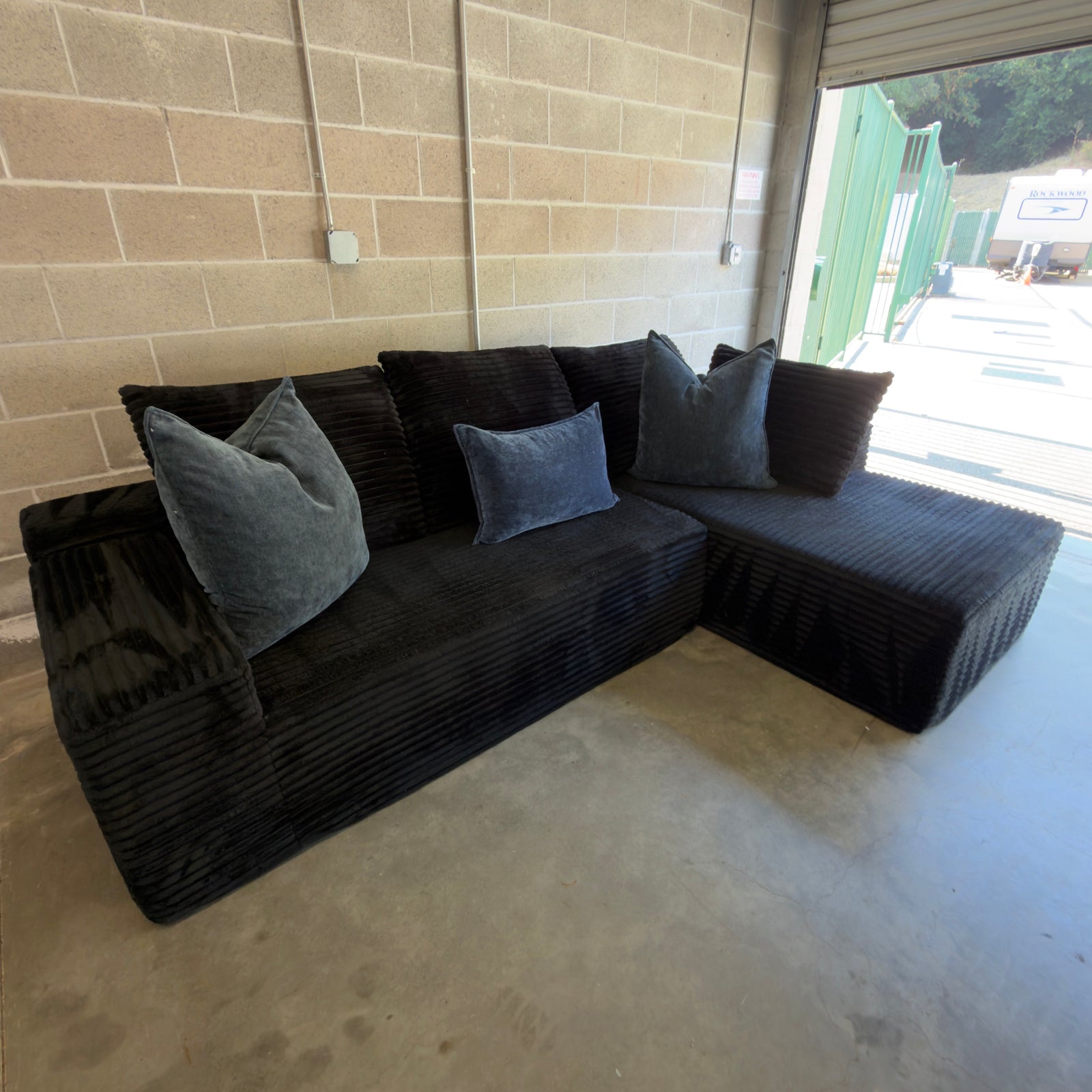 Black corduroy sectional styled with gray accent pillows