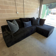 Black corduroy sectional styled with gray accent pillows