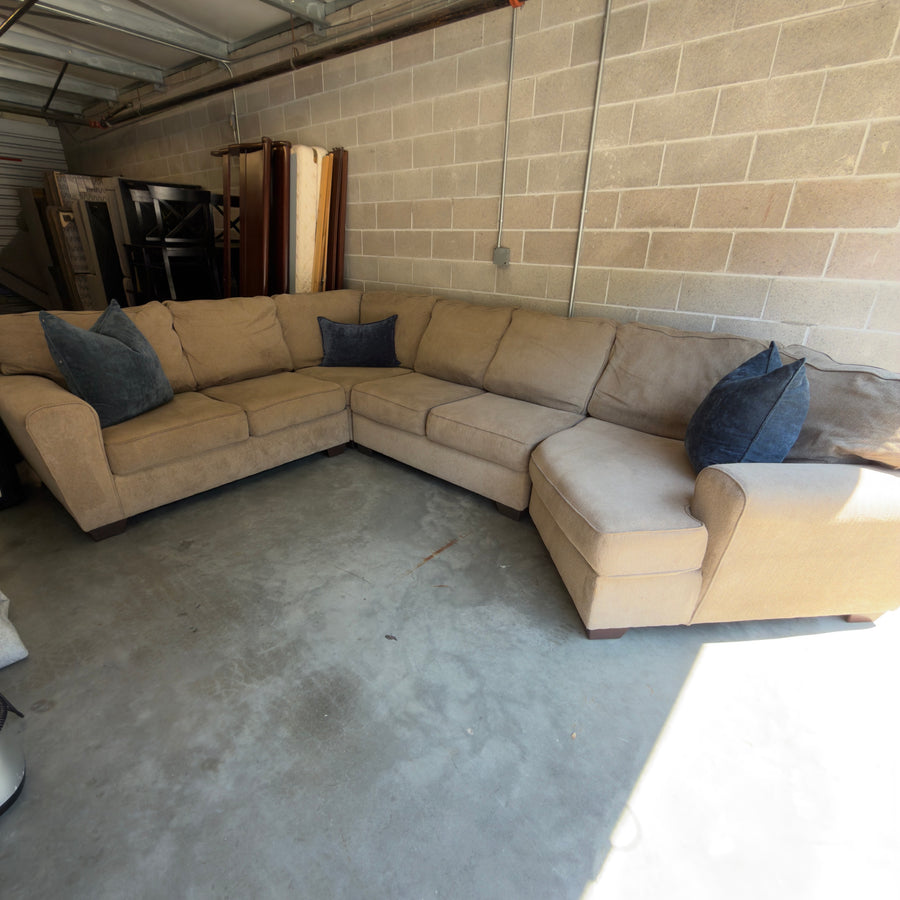 Tan fabric sectional sofa, full view showing chaise end