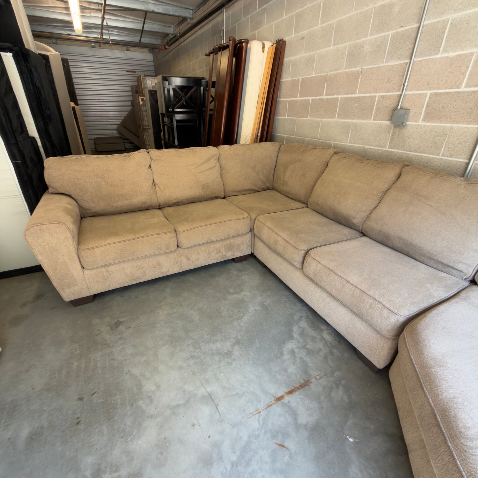 Tan fabric sectional sofa, view showing corner seat and chaise arm