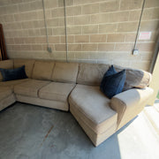 Tan fabric sectional sofa, close-up of the chaise cushion and arm
