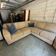 Tan fabric sectional sofa, close-up of the corner seat area