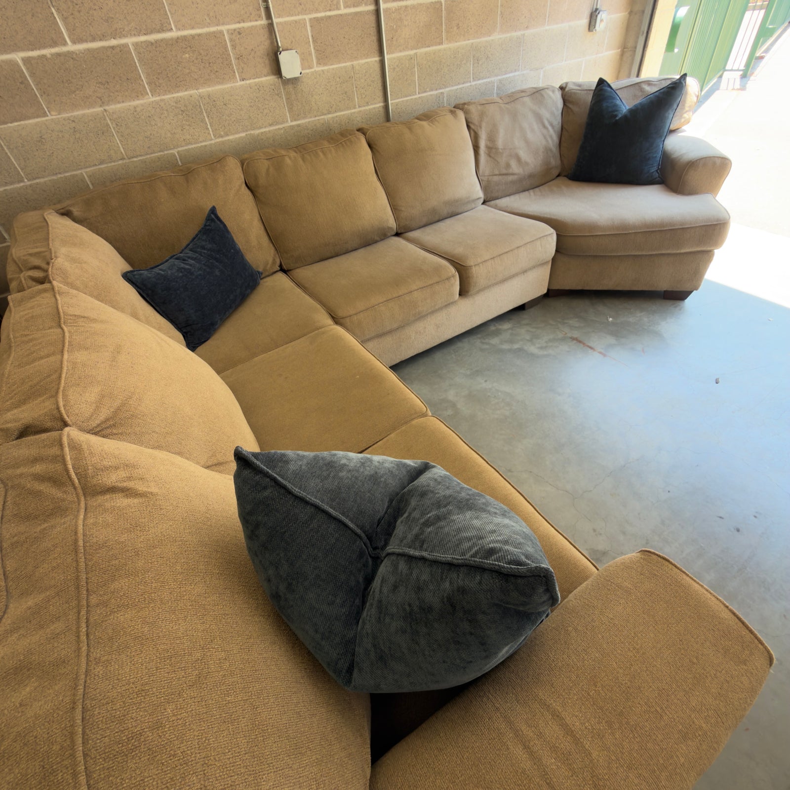 Tan fabric sectional sofa, front view of the corner and short run