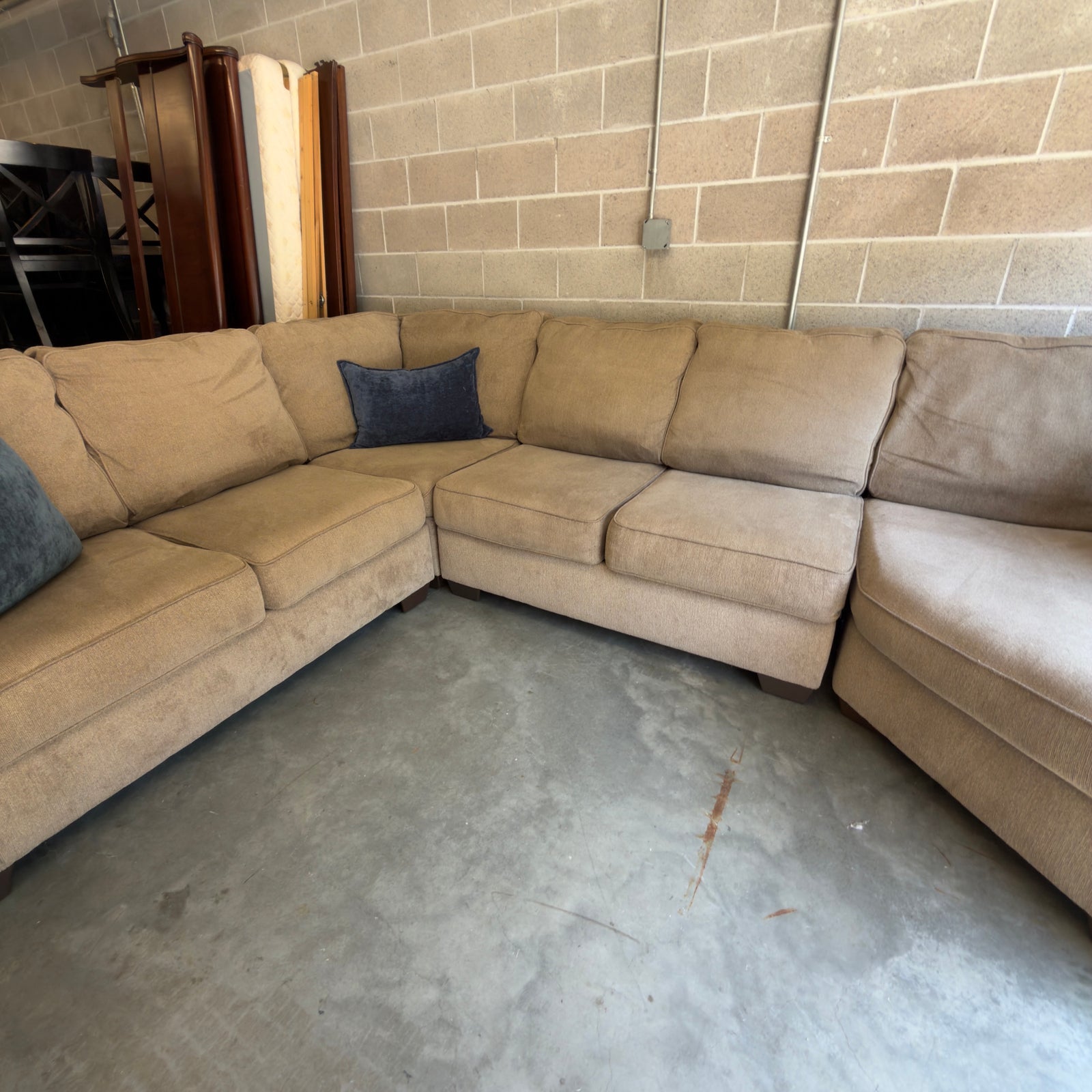 Tan fabric sectional sofa, straight-on view of the corner seating