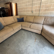 Tan fabric sectional sofa, straight-on view of the corner seating