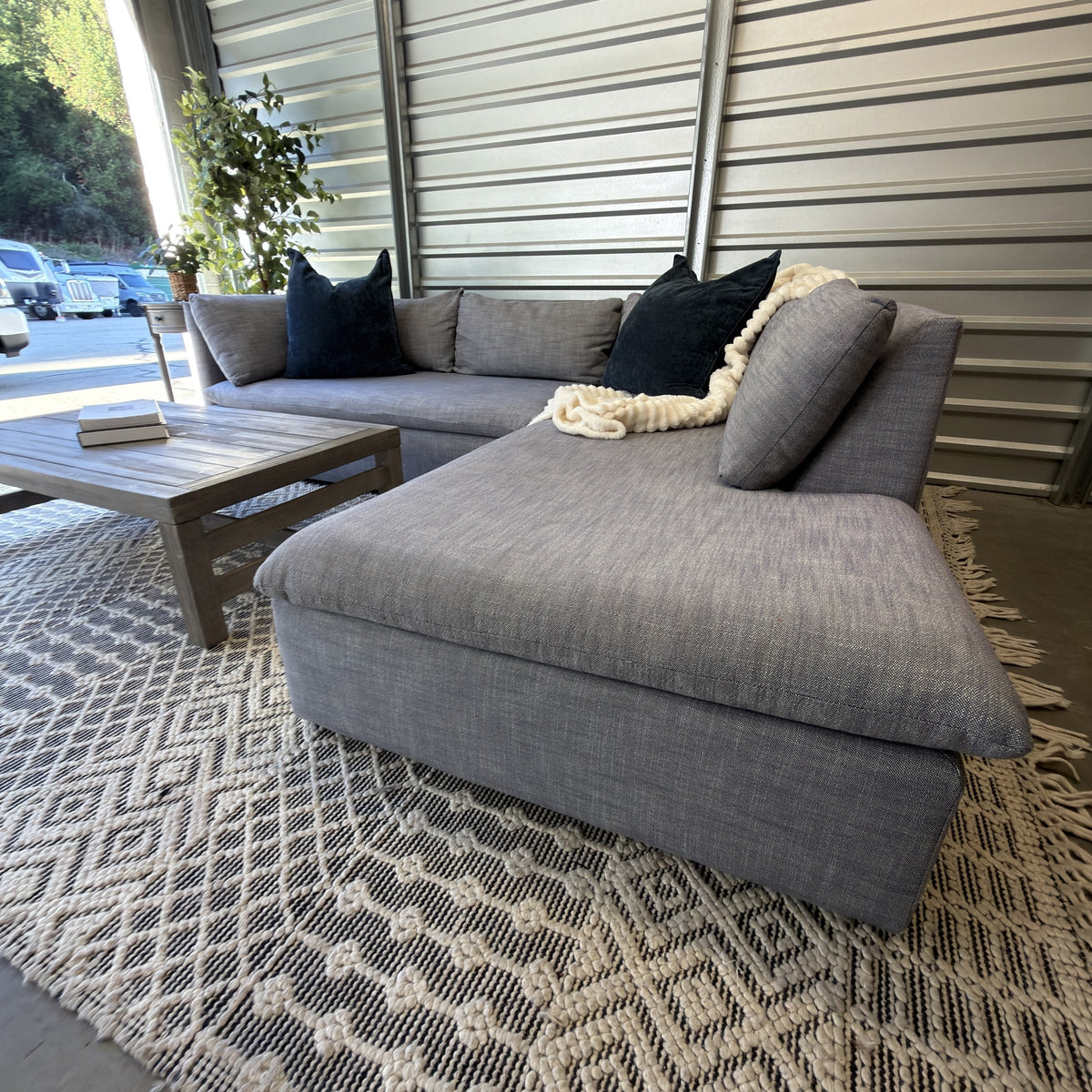 West Elm Shelter right bumper chaise staged with blue pillows and cream throw