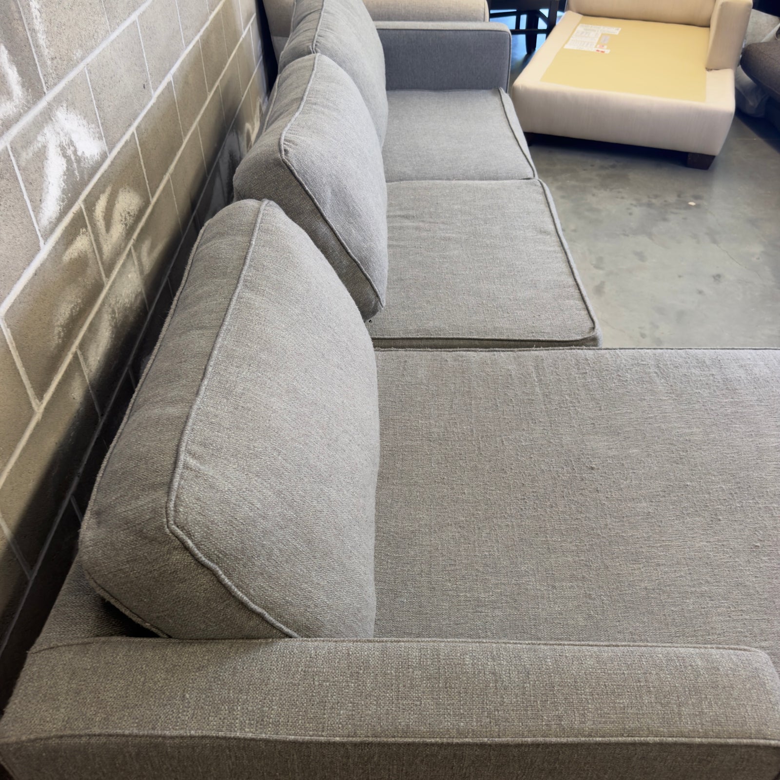Gray Living Spaces Calais III sectional sofa, side view in warehouse