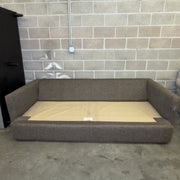 Brown Crate & Barrel sofa frame without cushions, showing base structure