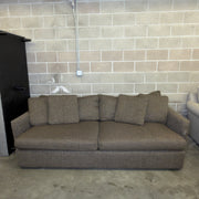 Brown Crate & Barrel tweed sofa, front view with accent pillow