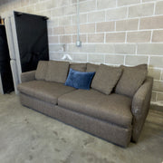 Brown Crate & Barrel tweed sofa, wide angle view in warehouse