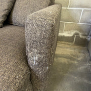 Close-up of worn and discolored fabric on the front-right arm corner